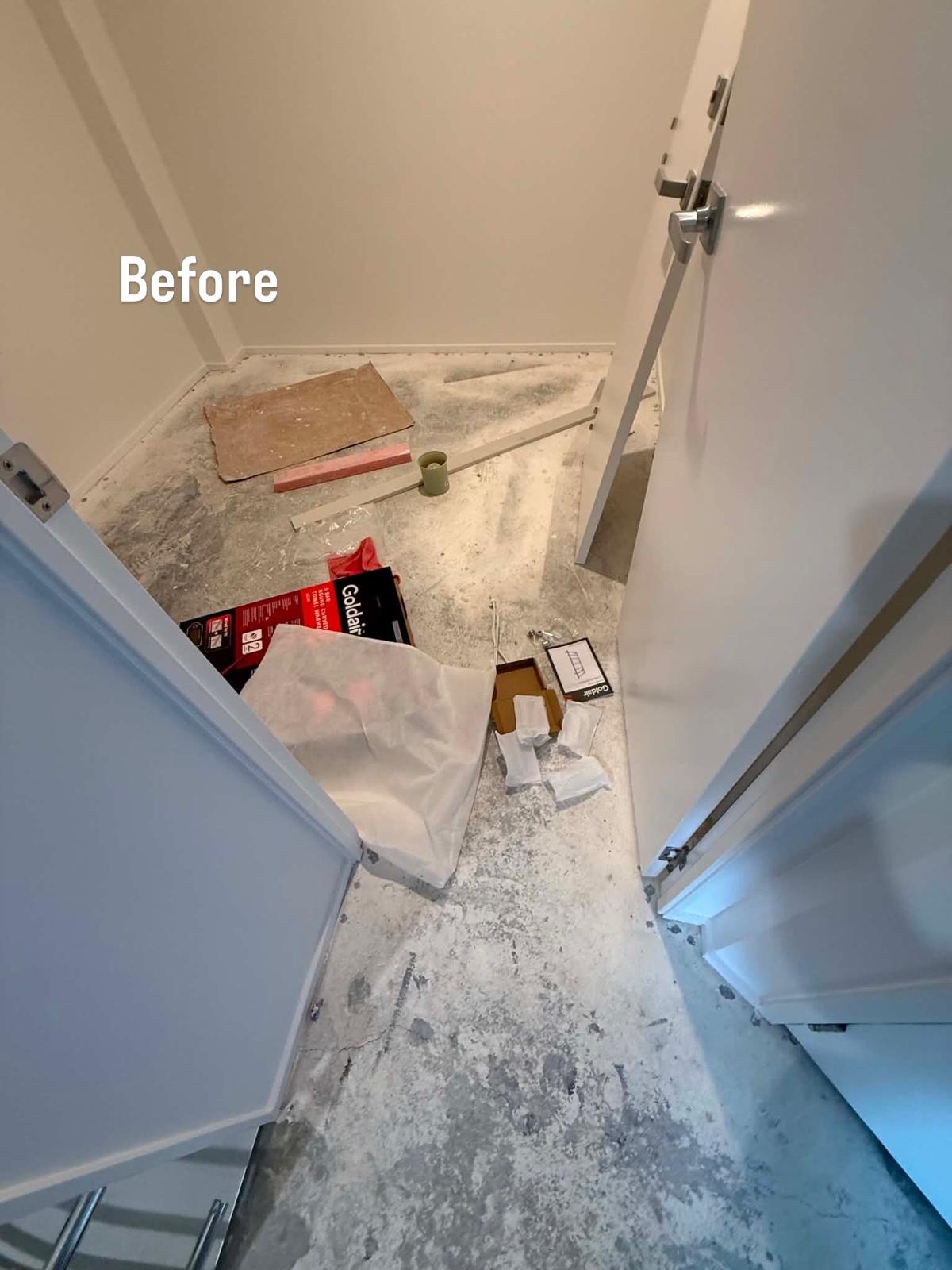 Storage cupboard stripped back to bare concrete with builder debris before new carpet